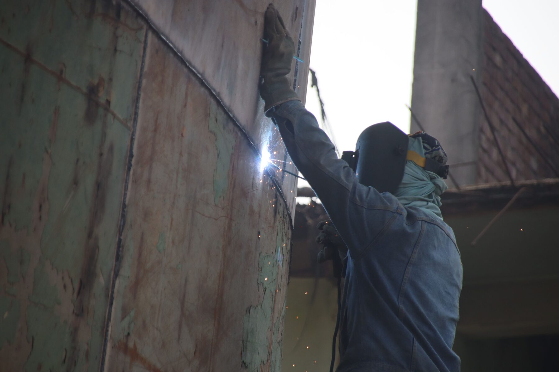 Soldador naval trabajando en la estructura de acero de un buque